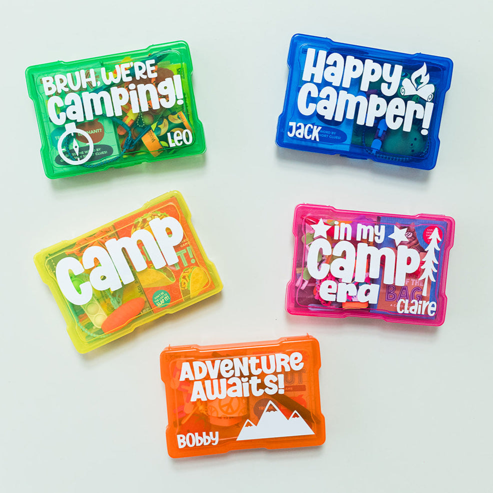 Personalized summer camp care boxes with various colorful contents visible, each box has different camp-related graphics and text personalizations.