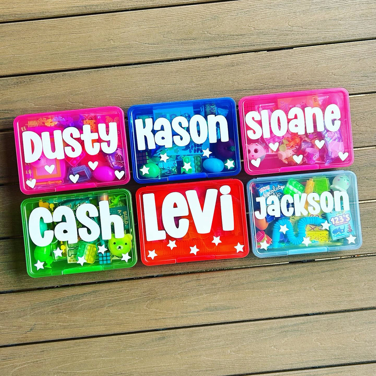 Six colorful nameplates with names on a wooden surface