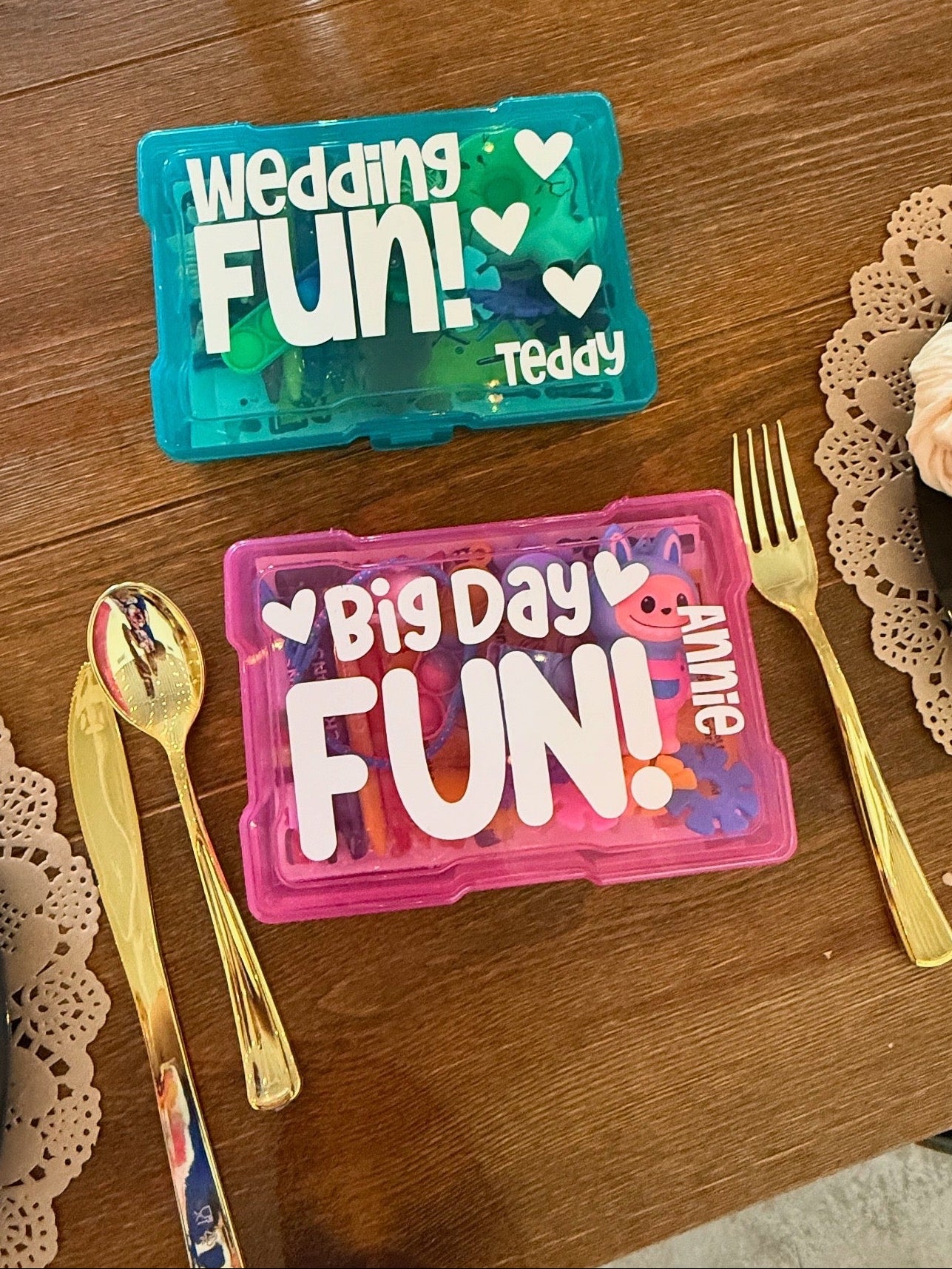 Two small plastic containers with text on a wooden surface