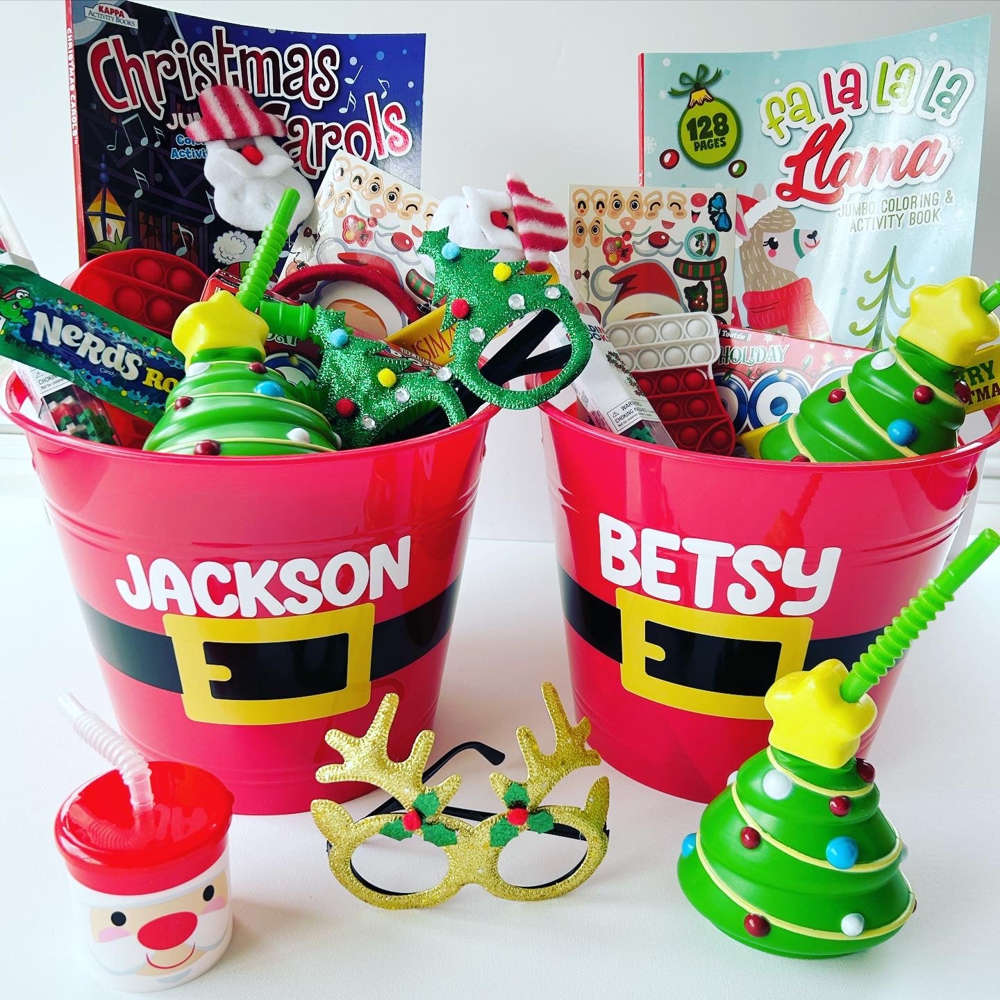 2 Christmas buckets filled with coloring books, activities, stickers, candy, cups and other Christmas goodies. Great gift for Christmas morning under the tree.