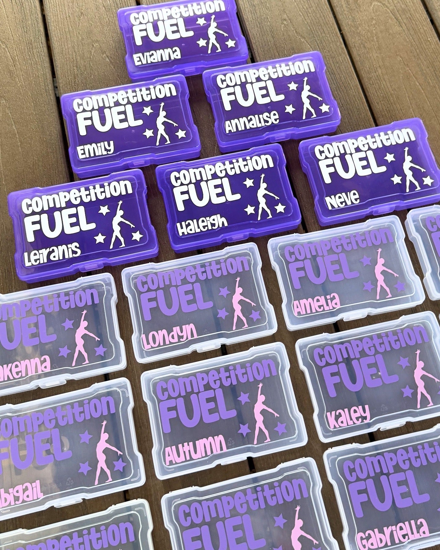 Multiple 'Competition Fuel' labels with names on a wooden surface