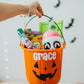 Orange Halloween bucket with 'Grace' printed on it, filled with treats and a ghost toy, against a white background.