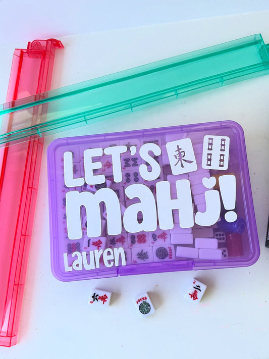 Mahjong game set with colorful cases and dice on a white background