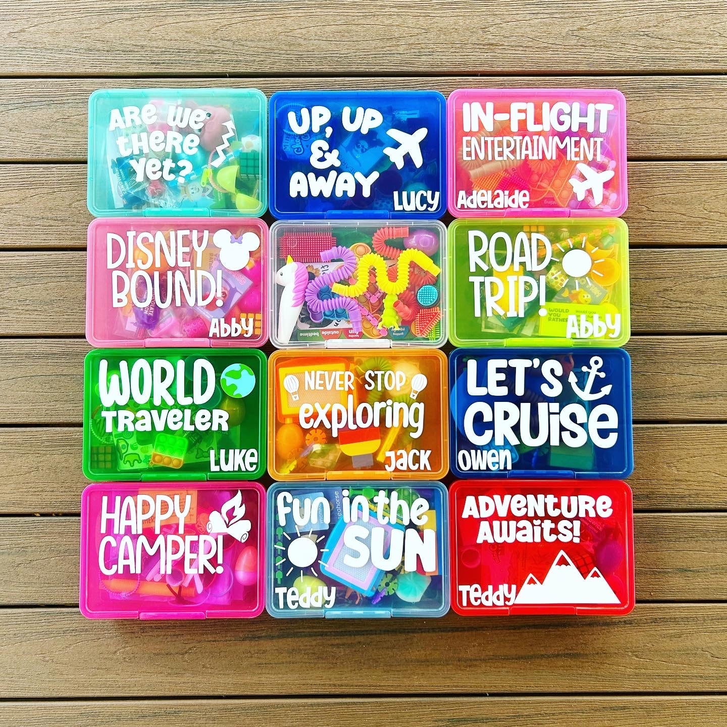 Collection of colorful small containers with various sayings on a wooden surface