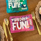 Two small plastic containers with text on a wooden surface