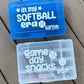 Two plastic containers with 'in my SOFTBALL era' and 'game day snacks' text on a wooden surface.