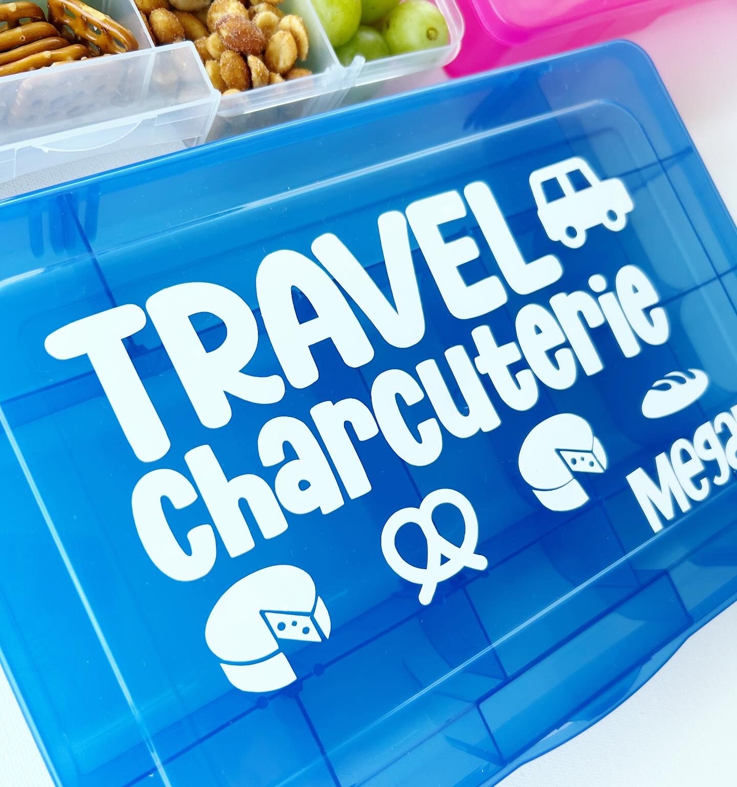 Blue container with 'Travel Charcuterie' text and icons on a white background