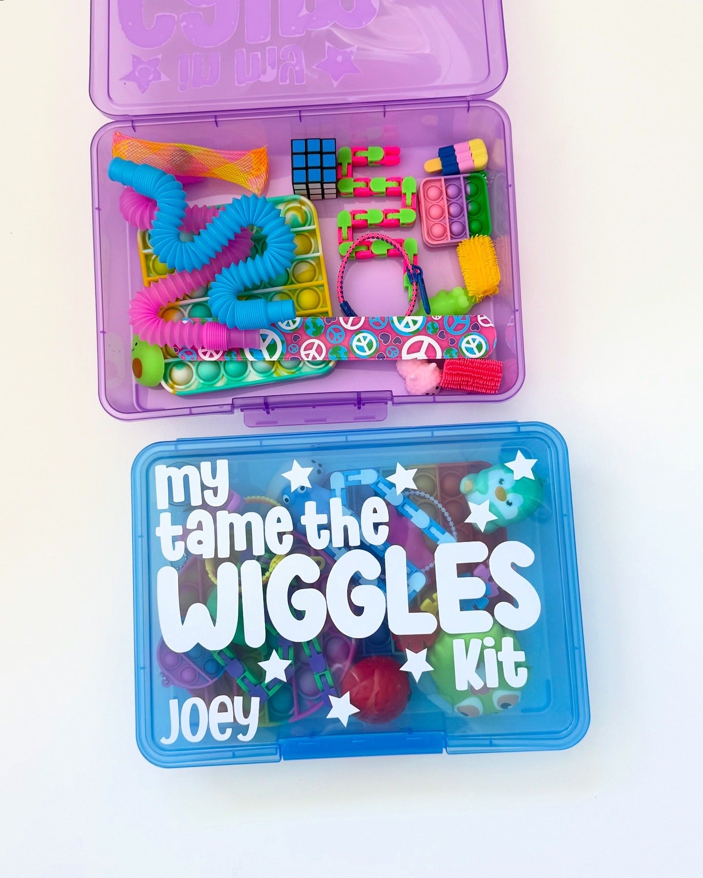 Colorful 'my tame the WIGGLES Kit' with various toys on a white background