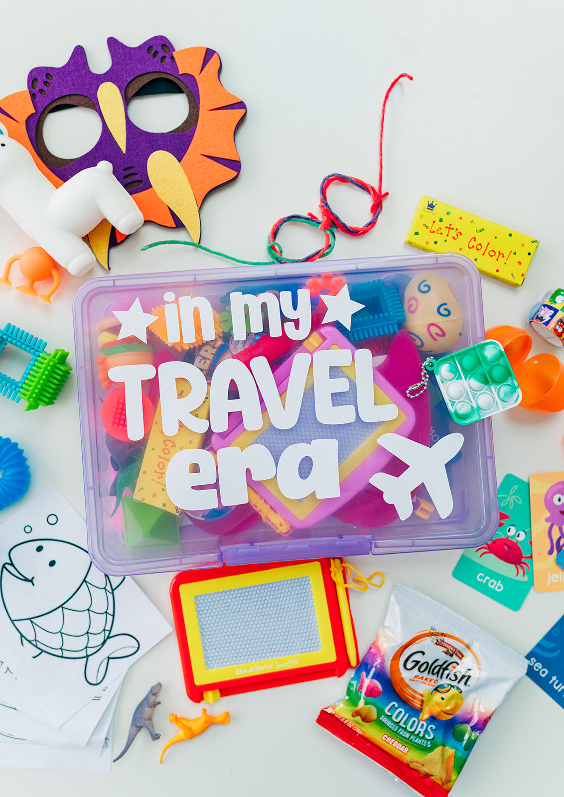 Travel-themed children's activity kit with colorful toys and items on a white background