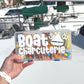 May include: A clear plastic container with a white label that reads &#39;Boat Charcuterie&#39;. The container is filled with various snacks, including pretzels, popcorn, and candy. The container has a blue latch.