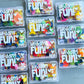 Small clear containers labeled 'Wedding Fun!' with colorful contents on a gray surface. Wedding activity kits for kids filled with wedding-themed activities for children, making these great wedding favors, flower girl or ring bearer gifts.