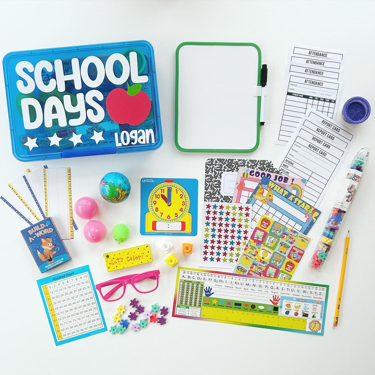 A blue plastic storage box with the words 'School Days' and a red apple. The box has three stars and the name 'Logan' written on it. The box is surrounded by various school supplies including a white board, a clock, a globe, a pencil, a ruler, a number chart, a set of alphabet tiles, a set of stickers, a set of report cards, a set of attendance sheets, a set of building blocks, a set of crayons, a set of glasses, a set of puzzle pieces, and a set of star stickers.