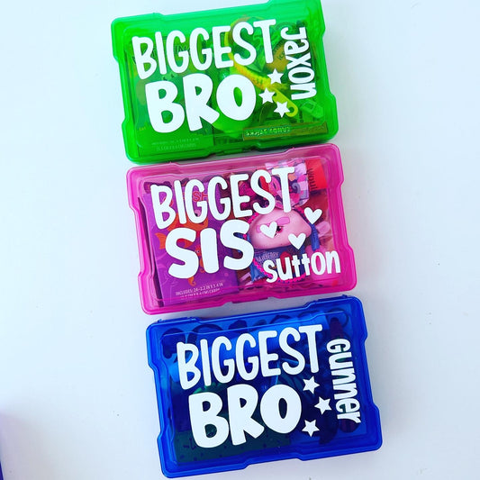 3 bright colored busy boxes for kids filled with activities. Green box says biggest bro with name Jaxon. Pink box with biggest sis and the name Sutton. Blue box with biggest bro and name Gunner.