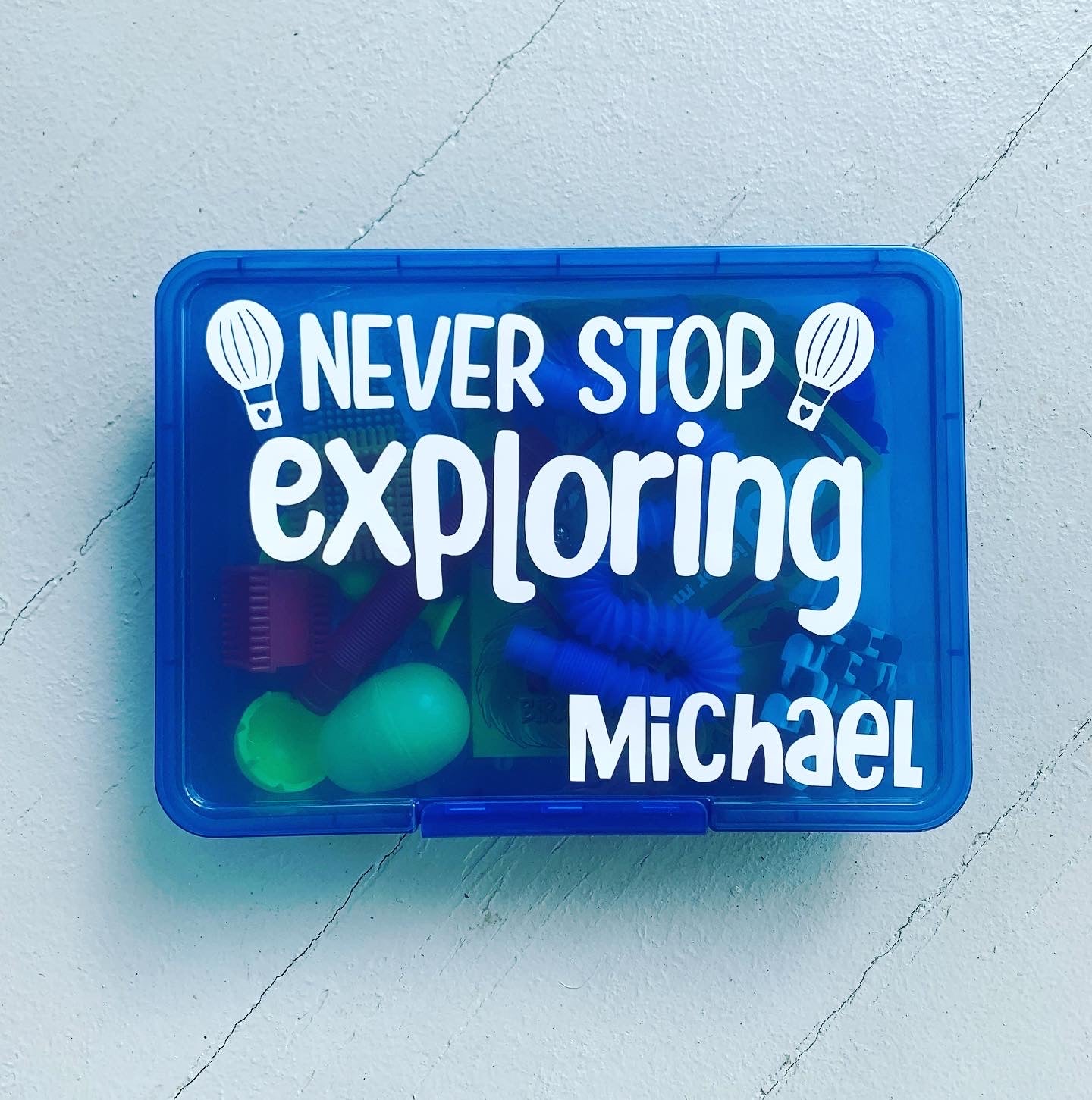 Blue busy box with never stop exploring wording, name Michael and 2 hot air balloons